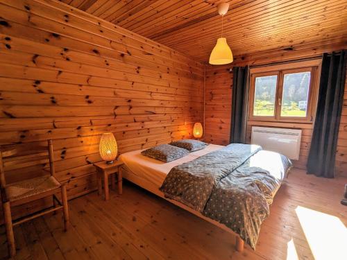 une chambre avec un lit et un mur en bois dans l'établissement Chalet rénové calme avec terrasse et cheminée à Ventron - FR-1-589-783, à Ventron