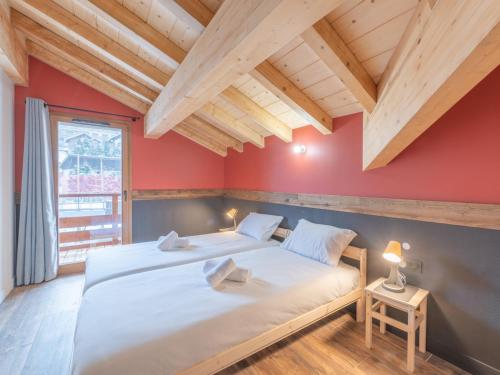 une chambre avec un grand lit et un mur rouge dans l'établissement Appartement ski aux pieds avec wifi et parking - FR-1-645-83, à Huez