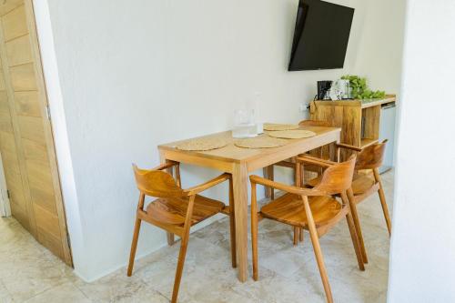 a dining room table with four chairs and a television at Condos Privados en Huatulco in Tangolunda