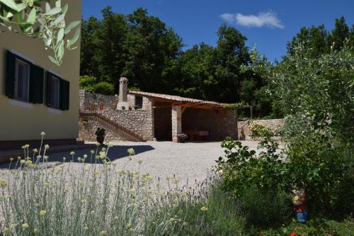 a garden with a building in the background at Apartments Sandra in Brseč