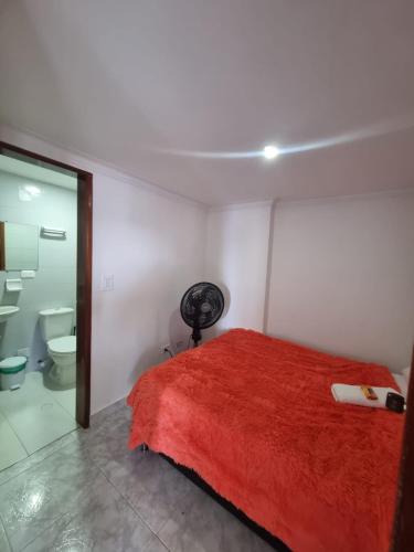 a bedroom with a red bed and a toilet at Bahía Fragata 803A in San Andrés