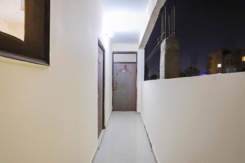 a hallway with a door in a white building at Hotel O Royal Residenc in Indirapuram
