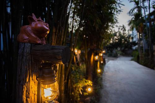 a small pig head on the side of a fence with lights at Hoi An Fairy Garden Villa in Hoi An