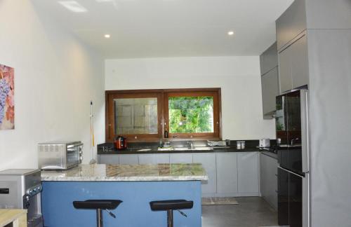 a kitchen with a blue island in the middle at 2 Bedroom Villa with Pool & Close to Setangi Beach in Mangsit