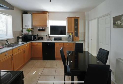 a kitchen with wooden cabinets and a table with chairs at Lodge Park - 2 minutes walk to Stoke Hospital in Stoke on Trent