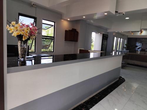 a lobby with a counter with a vase of flowers at RedDoorz at Pilgrims Hotel in Bulatok