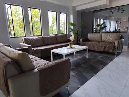a living room with couches and a coffee table at RedDoorz at Pilgrims Hotel in Bulatok