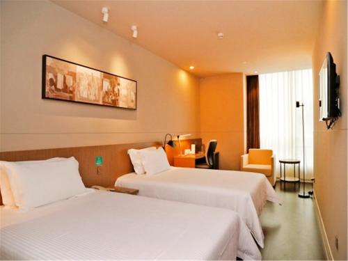 una camera d'albergo con 2 letti e una scrivania di Jinjiang Inn Selected Shenzhen Huanggang Port Huangcheng Plaza a Shenzhen