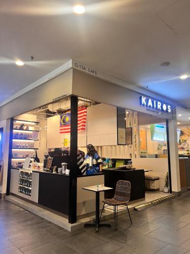 a karma store with a woman standing at a counter at SS15 Courtyard Subang Jaya Sunway 3 Pax Studio Big 65 Inch TV Netflix WiFi #21 in Subang Jaya