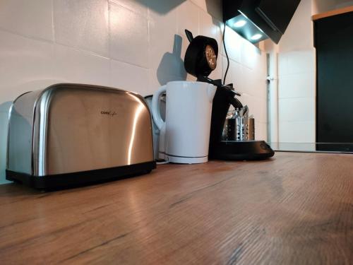 un grille-pain assis sur un comptoir à côté d'une tasse dans l'établissement Charismatique Orangerie-10min Parlement EU-WiFi-TV, à Strasbourg