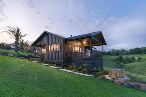 a modern house on a hill with a green field at Black Cockatoo Coorabell in Coorabell Creek