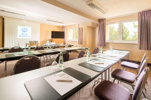 a conference room with tables and chairs and a tv at Best Western Hotel Jena in Jena