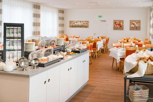 a restaurant with a buffet of food and tables at Best Western Blankenburg Hotel in Coburg