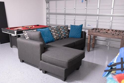 a living room with a couch and a pool table at Sea Lion Serenity Retreat - New Construction 2024 in Port Saint Lucie