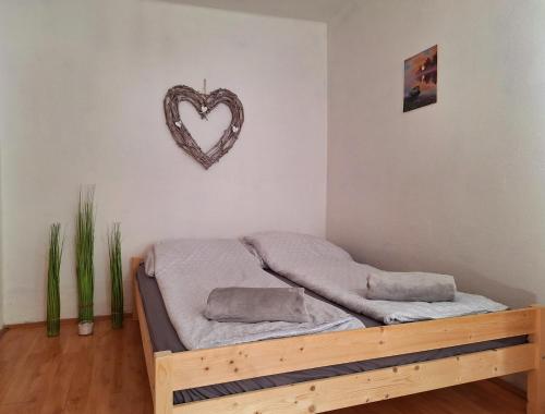 a bedroom with a bed with a heart sign on the wall at WatAir House Apartman Sarud in Sarud