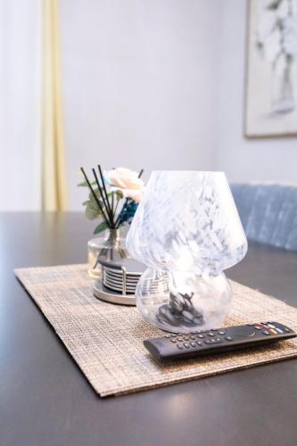 a lamp and a remote control on a table at Sea Lion Serenity Retreat - New Construction 2024 in Port Saint Lucie
