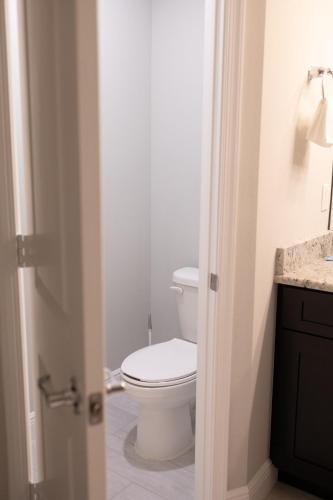 a bathroom with a white toilet and a sink at Sea Lion Serenity Retreat - New Construction 2024 in Port Saint Lucie