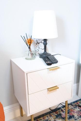a white dresser with a lamp on top of it at Sea Lion Serenity Retreat - New Construction 2024 in Port Saint Lucie