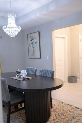 a dining room table with chairs and a chandelier at Sea Lion Serenity Retreat - New Construction 2024 in Port Saint Lucie