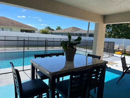 a dining room table with a vase with a plant at Sea Lion Serenity Retreat - New Construction 2024 in Port Saint Lucie