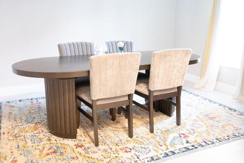 a dining room table and chairs on a rug at Sea Lion Serenity Retreat - New Construction 2024 in Port Saint Lucie
