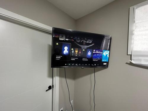 a flat screen tv hanging on a wall at Entire 2 Ensuite Bedrooms in a Basement in Edmonton