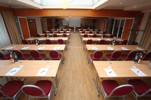 a lecture hall with desks and red chairs at Best Western Hotel Rosenau in Bad Nauheim
