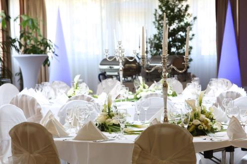 a dining room with white tables and chairs at Best Western Hotel Rosenau in Bad Nauheim