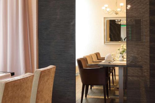 a dining room with a table with chairs and a mirror at Best Western Hotel Rosenau in Bad Nauheim