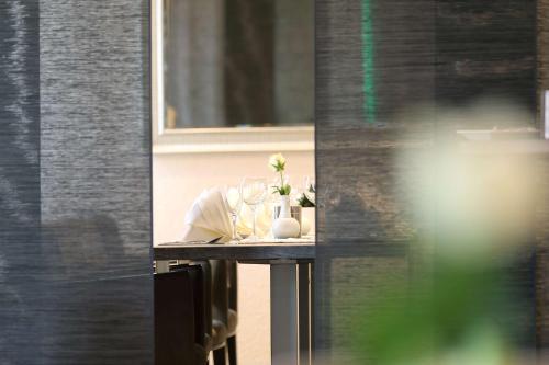 a table with glasses and a vase on it at Best Western Hotel Rosenau in Bad Nauheim