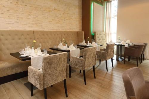 a dining room with tables and chairs and a brick wall at Best Western Hotel Rosenau in Bad Nauheim