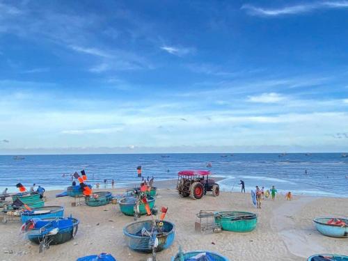 a group of people on a beach with boats at Homestay-Phước Hải in Chợ Phước Hải