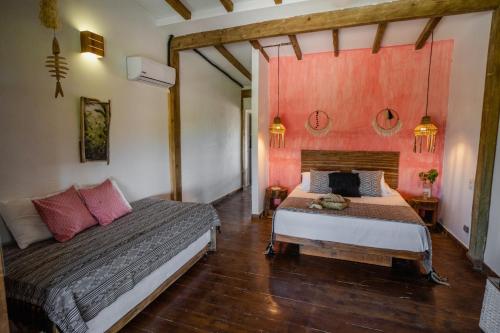 a bedroom with two beds and red walls at Casa del Mar by Al Alma in San Onofre