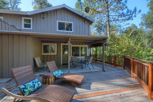 a wooden deck with chairs and a table at Tranquility House-Riverfront-Fireplace-Sleeps six in Oakhurst