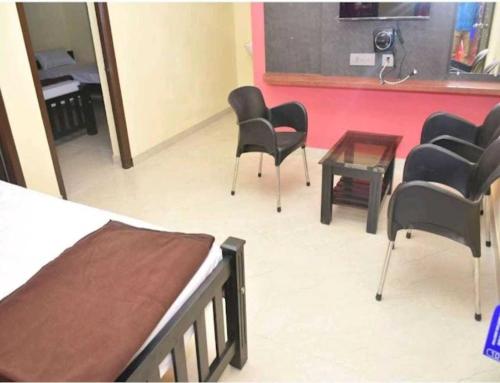 a room with chairs and a table and a classroom at New Pragathi Residency in Dharmastala