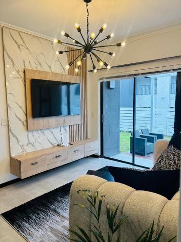 a living room with a large tv and a couch at Mandalay Boutique in Sandton