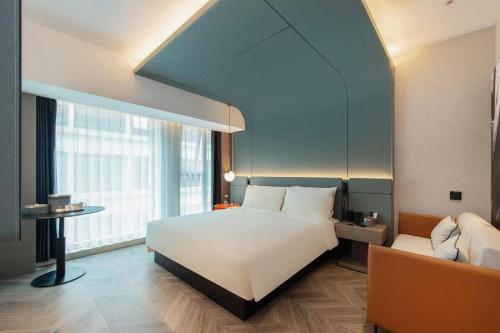 a bedroom with a large white bed and a couch at Atour Hotel Xi'an Qujiang Creative Valley in Xi'an