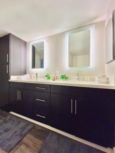 a bathroom with two sinks and two mirrors at 2BD 2BA Santa Monica Apartment with Relaxing Pool View in Los Angeles