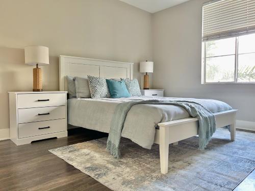 a white bedroom with a bed and a window at 2BD 2BA Santa Monica Apartment with Relaxing Pool View in Los Angeles