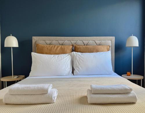 a bed with two pillows on it with two lamps at Yialos Village by Cybarco in Larnaca