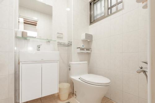 a white bathroom with a toilet and a sink at 飛日月漫旅Flying Sun & Moon in Yuchi