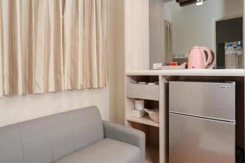 a small kitchen with a chair and a refrigerator at 飛日月漫旅Flying Sun & Moon in Yuchi