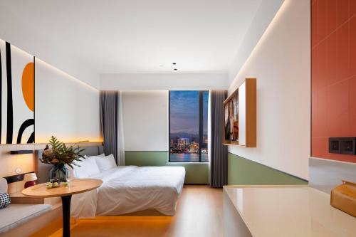 重慶市にあるMcsrh Hotel-Chongqing Jiefangbei Shibatiのベッドとテーブルと窓のある寝室