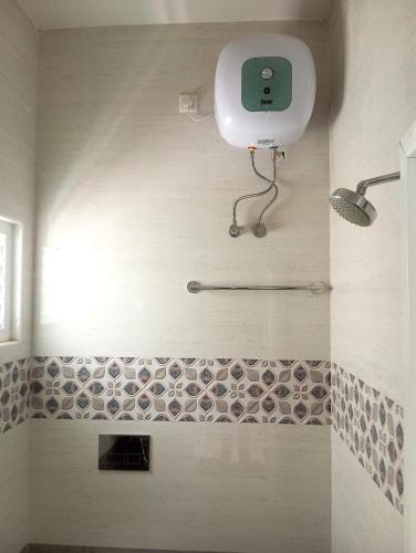 a bathroom with a toilet paper dispenser on the wall at Sky Stay Resorts in Yercaud