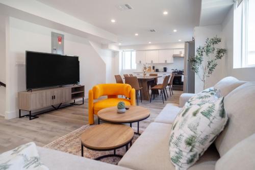 a living room with a couch and a flat screen tv at Stylish & Cozy Retreat Near USC & Downtown LA in Los Angeles