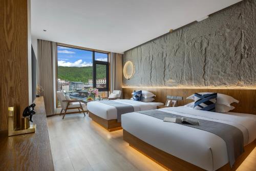 ein Hotelzimmer mit zwei Betten und Balkon in der Unterkunft Shangri La Anyu Garden Resort Hotel in Shangri-La