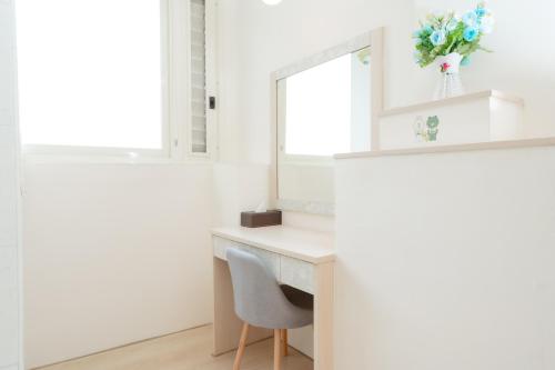a desk in a white room with a mirror and a chair at 飛日月漫旅Flying Sun & Moon in Yuchi