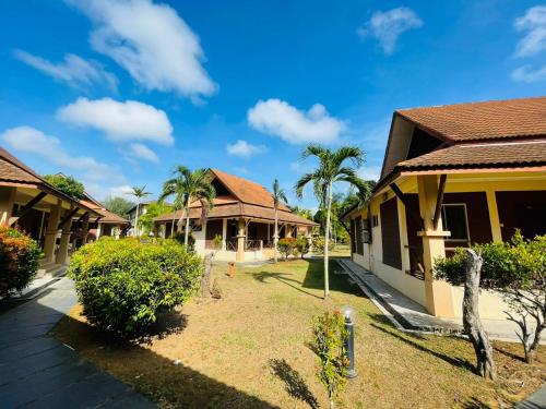 a row of houses with palm trees in front of them at Rompin Beach Resorts in Kuala Rompin