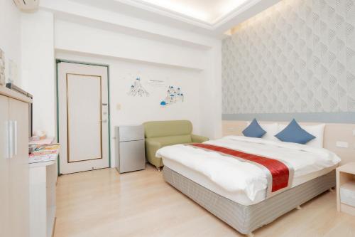 a white bedroom with a bed and a chair at 飛日月漫旅Flying Sun & Moon in Yuchi