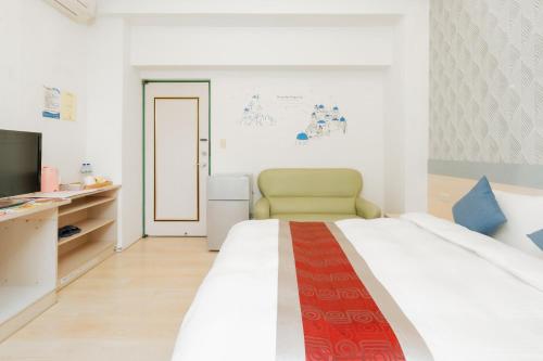 a bedroom with a large bed and a television at 飛日月漫旅Flying Sun & Moon in Yuchi